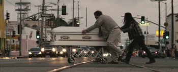 Movie still from “Hesher” (2010), directed by Spencer Susser – A man and woman pushing a casket down a street; Wide shot, Low angle