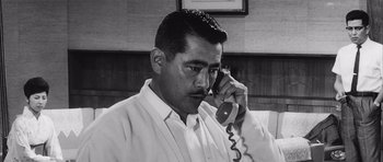 Movie still from “High and Low” (1963), directed by Akira Kurosawa – A black and white photo of a man talking on a phone; Close Up shot, Low angle
