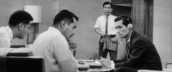 Movie still from “High and Low” (1963), directed by Akira Kurosawa – A group of men standing around a table; Medium shot, Low angle