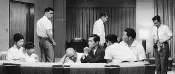 Movie still from “High and Low” (1963), directed by Akira Kurosawa – A black and white photo of a group of men sitting on a couch; Wide shot, Low angle