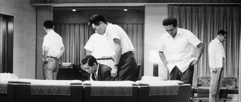 Movie still from “High and Low” (1963), directed by Akira Kurosawa – A group of men standing around a table; Medium shot, Low angle