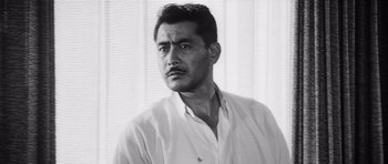Movie still from “High and Low” (1963), directed by Akira Kurosawa – Black and white photograph of a man in a white shirt; Close Up shot, Low angle