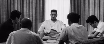 Movie still from “High and Low” (1963), directed by Akira Kurosawa – A group of people sitting around a table; Medium shot, Low angle
