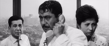Movie still from “High and Low” (1963), directed by Akira Kurosawa – A black and white photo of a man holding a phone to his ear; Close Up shot, Low angle