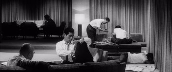 Movie still from “High and Low” (1963), directed by Akira Kurosawa – A group of people in a living room setting; Medium shot, Low angle