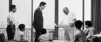 Movie still from “High and Low” (1963), directed by Akira Kurosawa – Two men and a boy standing in front of an open window; Medium shot, Low angle