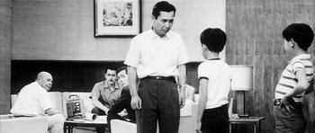 Movie still from “High and Low” (1963), directed by Akira Kurosawa – An old photo of a man and a young boy; Medium shot, Over the shoulder angle