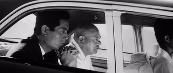 Movie still from “High and Low” (1963), directed by Akira Kurosawa – A man in a car with another man looking out of the window; Close Up shot, Low angle