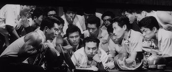 Movie still from “High and Low” (1963), directed by Akira Kurosawa – A group of men sitting in front of a computer screen; Medium shot, High angle