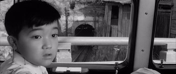 Movie still from “High and Low” (1963), directed by Akira Kurosawa – A young boy looking out of the window of a train car; Close Up shot, High angle