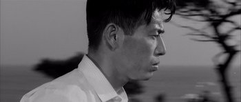 Movie still from “High and Low” (1963), directed by Akira Kurosawa – Black and white photograph of a young man's face; Close Up shot, Low angle