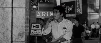 Movie still from “High and Low” (1963), directed by Akira Kurosawa – A black and white photo of a man smoking a cigarette; Medium shot, Low angle