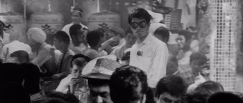 Movie still from “High and Low” (1963), directed by Akira Kurosawa – Black and white photograph of a crowd of people; Medium shot, Over the shoulder angle