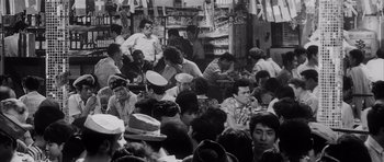 Movie still from “High and Low” (1963), directed by Akira Kurosawa – A group of people sitting around in a room; Medium shot, High angle