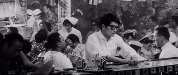 Movie still from “High and Low” (1963), directed by Akira Kurosawa – A black and white photo of people sitting at a table; Medium shot, High angle