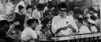 Movie still from “High and Low” (1963), directed by Akira Kurosawa – A man and a woman sitting at a table; Medium shot, Low angle