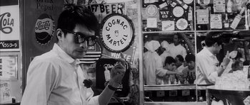 Movie still from “High and Low” (1963), directed by Akira Kurosawa – A man holding a sign in front of a wall; Close Up shot, Over the shoulder angle