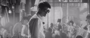 Movie still from “High and Low” (1963), directed by Akira Kurosawa – A young man in a white shirt and a bow tie; Close Up shot, Low angle