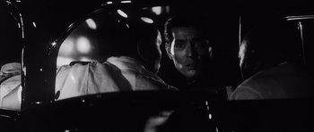 Movie still from “High and Low” (1963), directed by Akira Kurosawa – A man in a car looking at another man in the back seat; Close Up shot, Over the shoulder angle