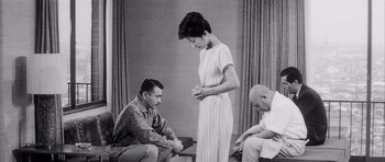 Movie still from “High and Low” (1963), directed by Akira Kurosawa – A man and a woman sitting next to each other in front of another man; Medium shot, High angle