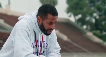 Movie still from “Higher Learning” (1995), directed by John Singleton – A man with a beard is sitting down; Close Up shot, High angle