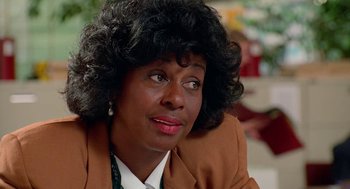 Movie still from “Higher Learning” (1995), directed by John Singleton – An older woman with curly black hair sitting in a room; Close Up shot, Over the shoulder angle
