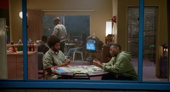 Movie still from “Higher Learning” (1995), directed by John Singleton – Two men sitting at a table playing a board game; Wide shot, High angle