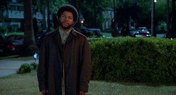 Movie still from “Higher Learning” (1995), directed by John Singleton – A man standing in the grass at night; Medium shot, Over the shoulder angle