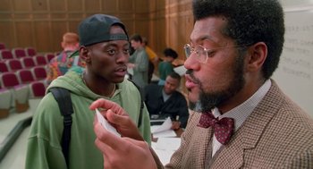 Movie still from “Higher Learning” (1995), directed by John Singleton – Two men are talking to each other at a gathering; Medium shot, Over the shoulder angle