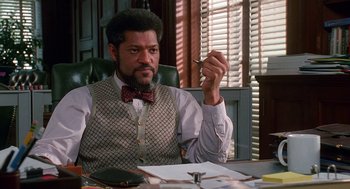 Movie still from “Higher Learning” (1995), directed by John Singleton – A man sitting at a desk in front of a window; Medium shot, Low angle