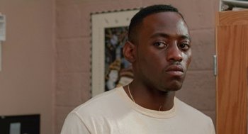 Movie still from “Higher Learning” (1995), directed by John Singleton – A person wearing a white t - shirt; Close Up shot, Over the shoulder angle