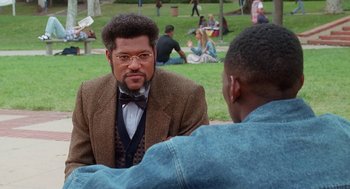 Movie still from “Higher Learning” (1995), directed by John Singleton – Two men sitting in a park talking to each other; Medium shot, Over the shoulder angle