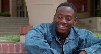 Movie still from “Higher Learning” (1995), directed by John Singleton – A man in a denim jacket smiling for the camera; Close Up shot, High angle