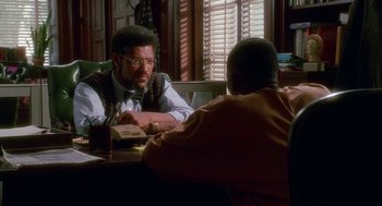 Movie still from “Higher Learning” (1995), directed by John Singleton – Two men sitting at a table in front of a book; Medium shot, Over the shoulder angle