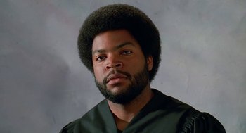 Movie still from “Higher Learning” (1995), directed by John Singleton – A man with a beard and a black shirt is posing for a picture; Close Up shot, Low angle