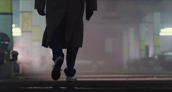 Movie still from “Highlander” (1986), directed by Russell Mulcahy – A person is walking down the street in the dark; Wide shot, Low angle