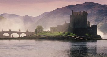Movie still from “Highlander” (1986), directed by Russell Mulcahy – A view of a castle from across the water; Extreme Wide shot, High angle