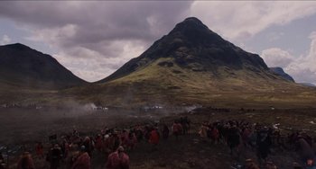 Movie still from “Highlander” (1986), directed by Russell Mulcahy – A group of people gathered in the middle of a field; Extreme Wide shot, High angle
