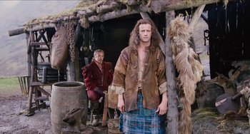 Movie still from “Highlander” (1986), directed by Russell Mulcahy – A man in brown jacket standing next to another man in brown jacket; Medium shot, Low angle