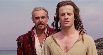 Movie still from “Highlander” (1986), directed by Russell Mulcahy – A man and a woman standing next to each other; Close Up shot, Over the shoulder angle