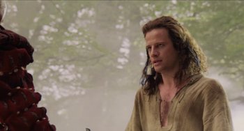 Movie still from “Highlander” (1986), directed by Russell Mulcahy – A man with long brown hair wearing a brown shirt; Medium shot, Over the shoulder angle
