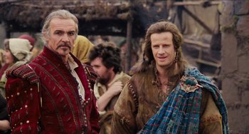 Movie still from “Highlander” (1986), directed by Russell Mulcahy – Two men in medieval garb standing next to each other; Medium shot, Over the shoulder angle