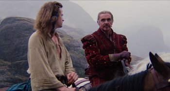 Movie still from “Highlander” (1986), directed by Russell Mulcahy – Two men in medieval garb standing next to each other; Medium shot, Over the shoulder angle