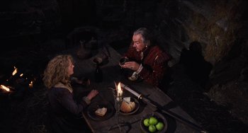 Movie still from “Highlander” (1986), directed by Russell Mulcahy – Two people sitting at a dinner table with a candle; Medium shot, High angle
