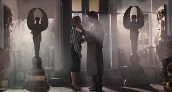 Movie still from “Highlander” (1986), directed by Russell Mulcahy – A man and a woman standing next to each other in front of a building; Medium shot, Low angle