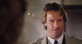 Movie still from “Highlander” (1986), directed by Russell Mulcahy – A person wearing a suit and tie; Close Up shot, Over the shoulder angle