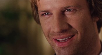 Movie still from “Highlander” (1986), directed by Russell Mulcahy – A person smiling for the camera; Close Up shot, Over the shoulder angle