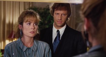 Movie still from “Highlander” (1986), directed by Russell Mulcahy – A man and a woman standing next to each other in front of a mirror; Close Up shot, Over the shoulder angle