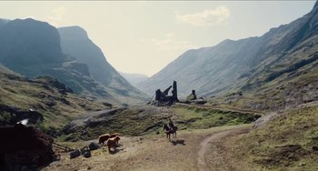 Movie still from “Highlander” (1986), directed by Russell Mulcahy – A herd of cattle grazing on a lush green hillside; Extreme Wide shot, Low angle