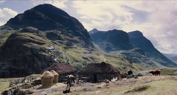 Movie still from “Highlander” (1986), directed by Russell Mulcahy – A group of people standing on top of a grass covered hillside; Extreme Wide shot, High angle